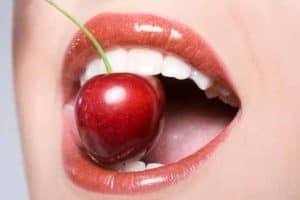 Close-up on woman's mouth with cherry